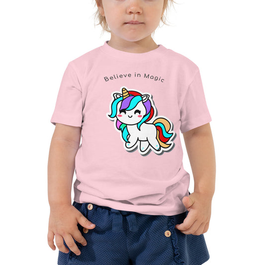 Toddler girl wearning pink t-shirt with smiling unicorn graphic