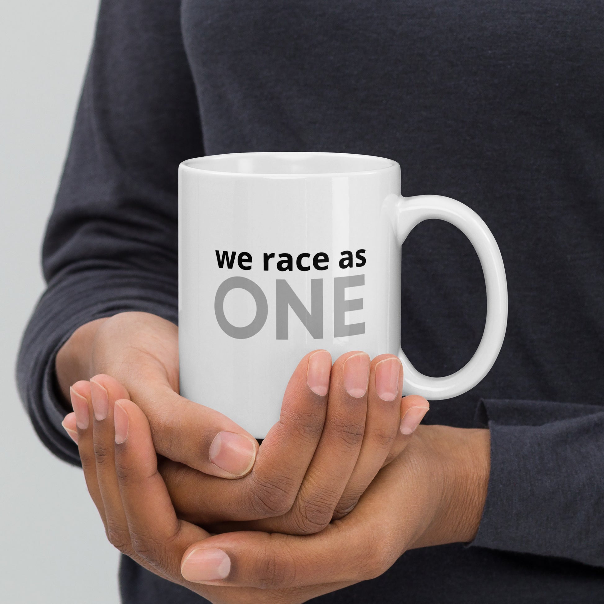 coffee mug showing the text "we race as one"